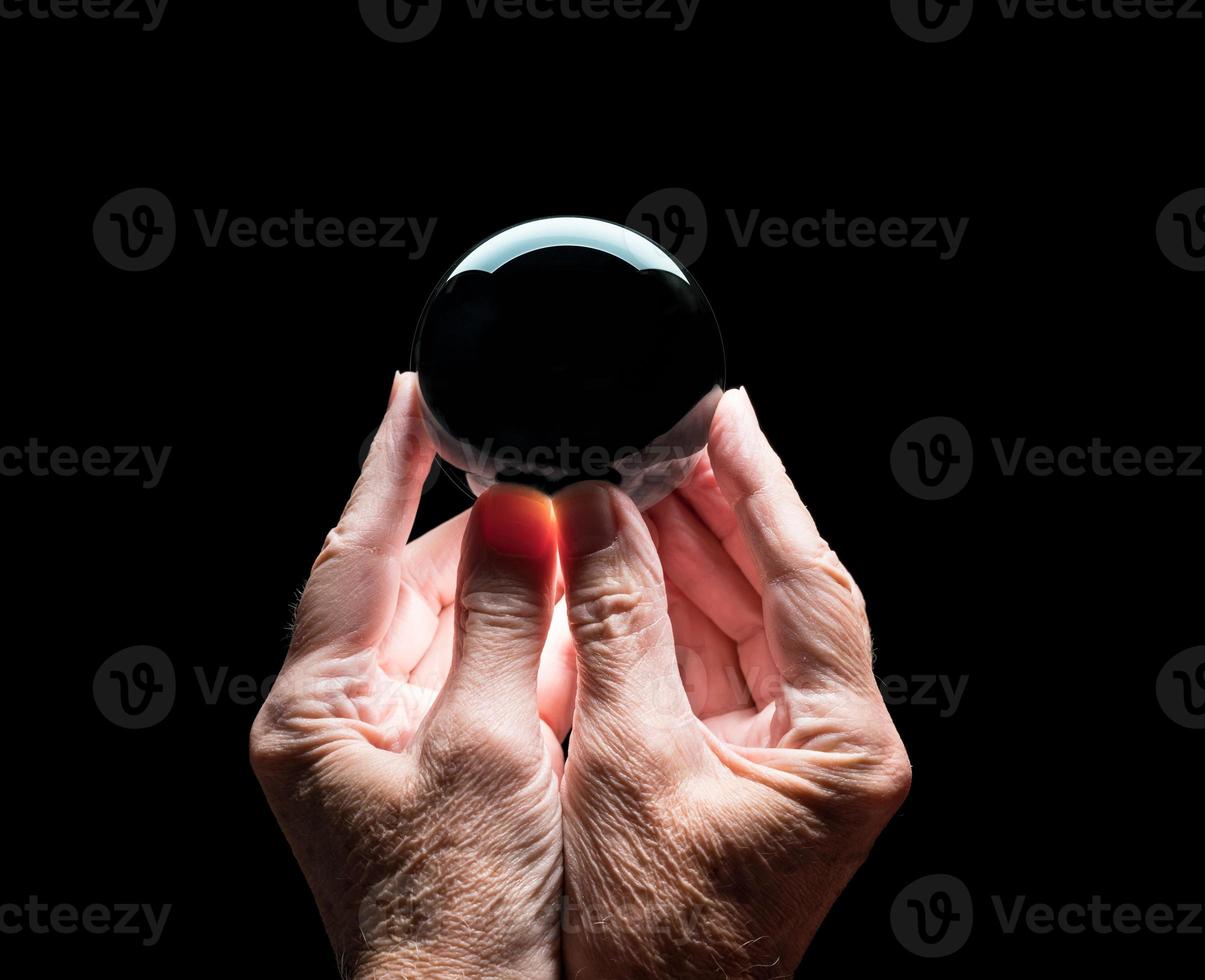 mani che tengono una sfera di previsione in vetro cristallo con centro nero per consentire facili compositi foto