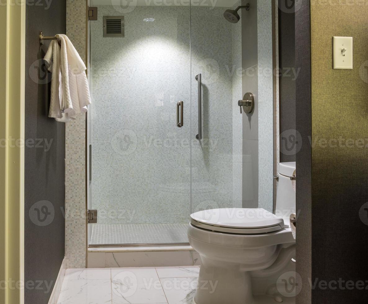 bagno moderno dell'hotel con doccia e servizi igienici a parete in vetro foto