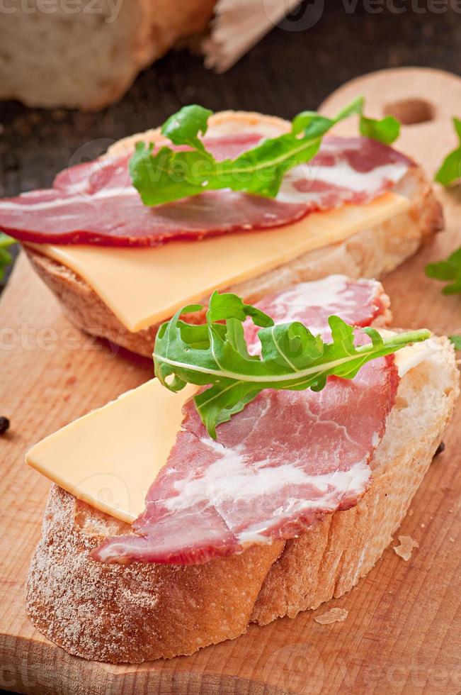 panino al prosciutto decorato con foglie di rucola foto