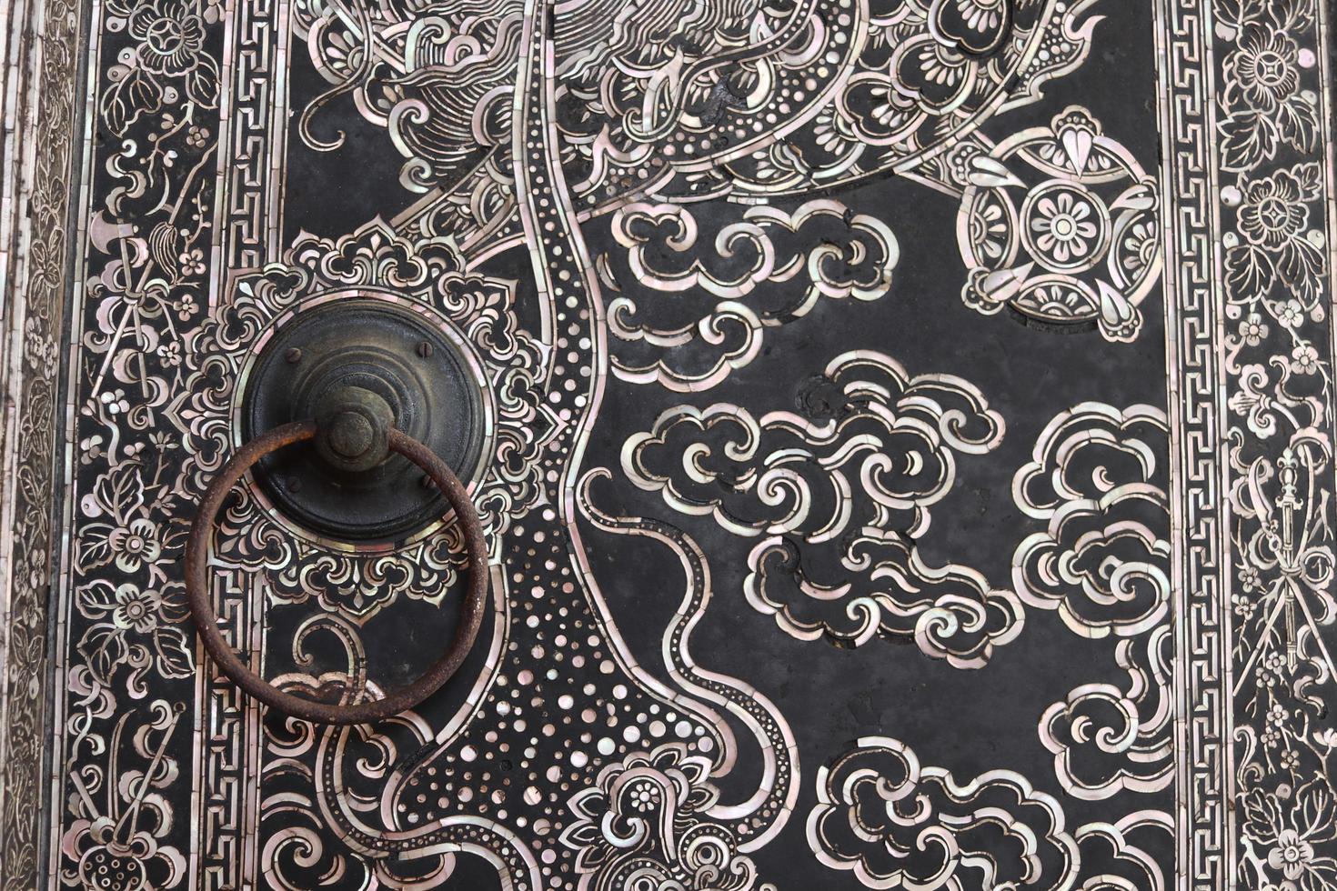 la maniglia della porta in ferro vecchio stile è sulla pittura tailandese antica porta nativa della chiesa, tailandia. foto