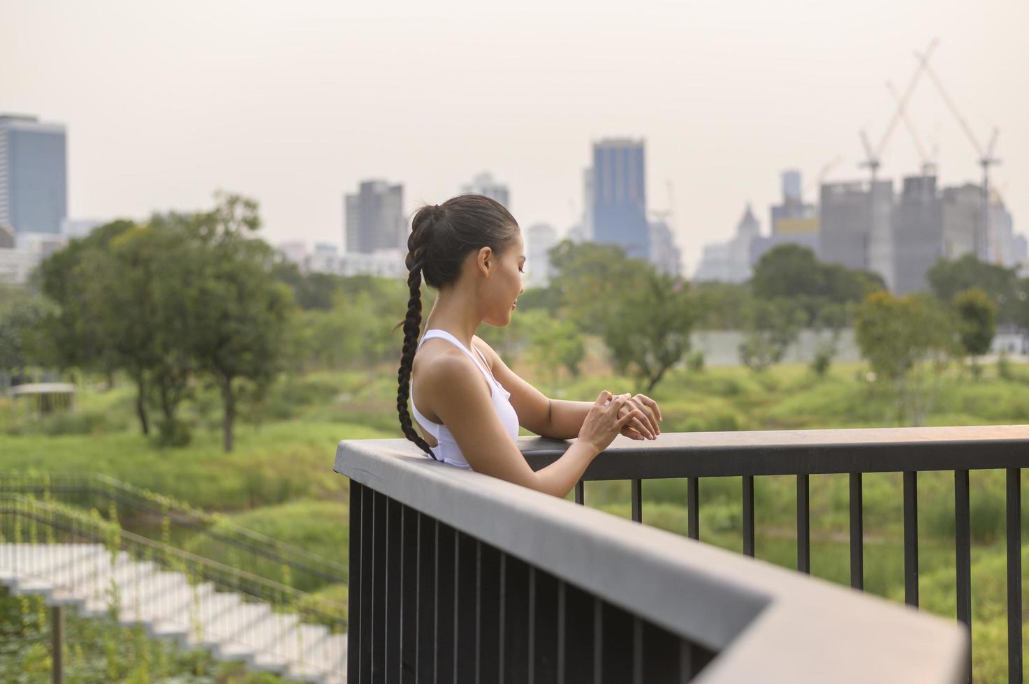 una giovane donna fitness in abbigliamento sportivo che utilizza smartwatch mentre ti alleni nel parco cittadino, sano e stili di vita. foto