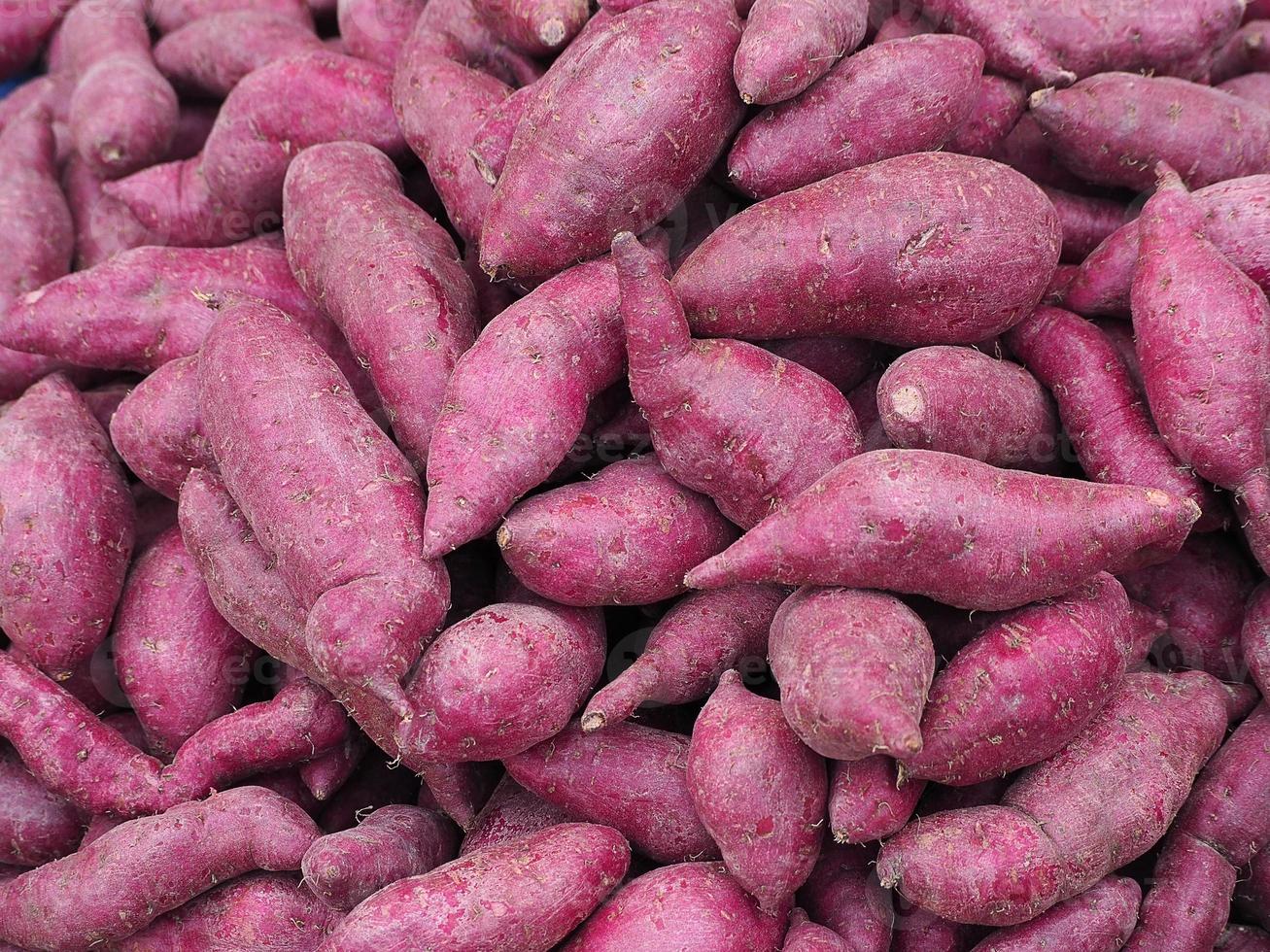 mucchio di patate dolci viola fresche organiche per la vendita nel mercato foto