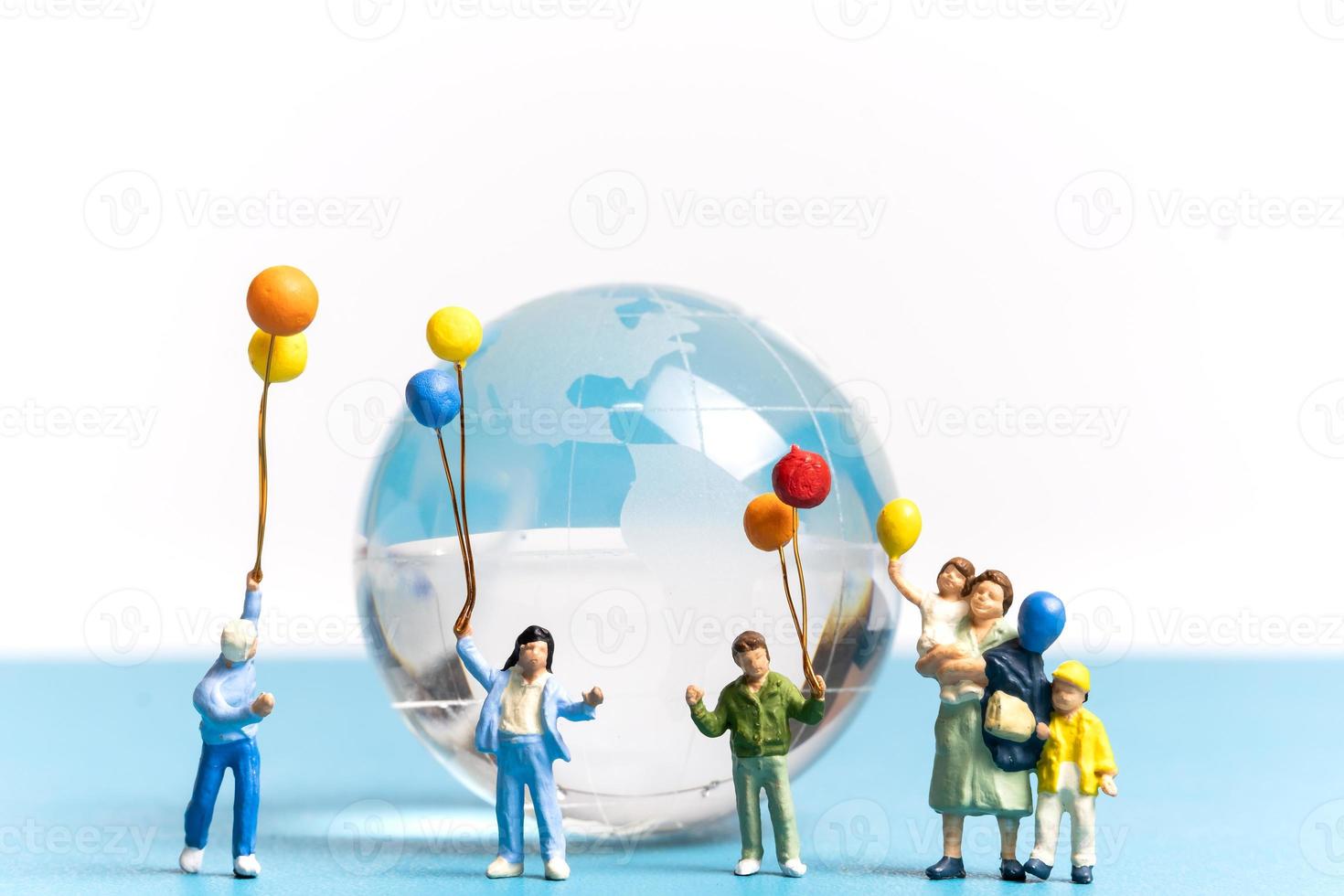 la gente in miniatura che tiene il pallone con il globo di cristallo foto