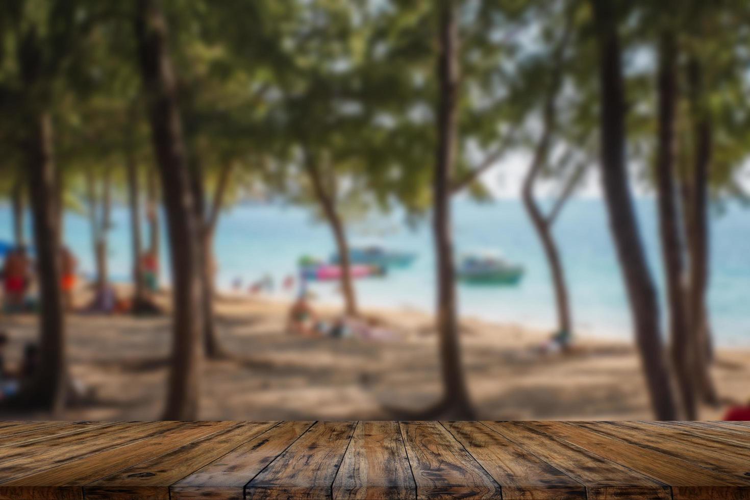 tavolo in legno su sfondo sfocato di pini mare e cielo blu per visualizzare o modificare i tuoi prodotti. foto