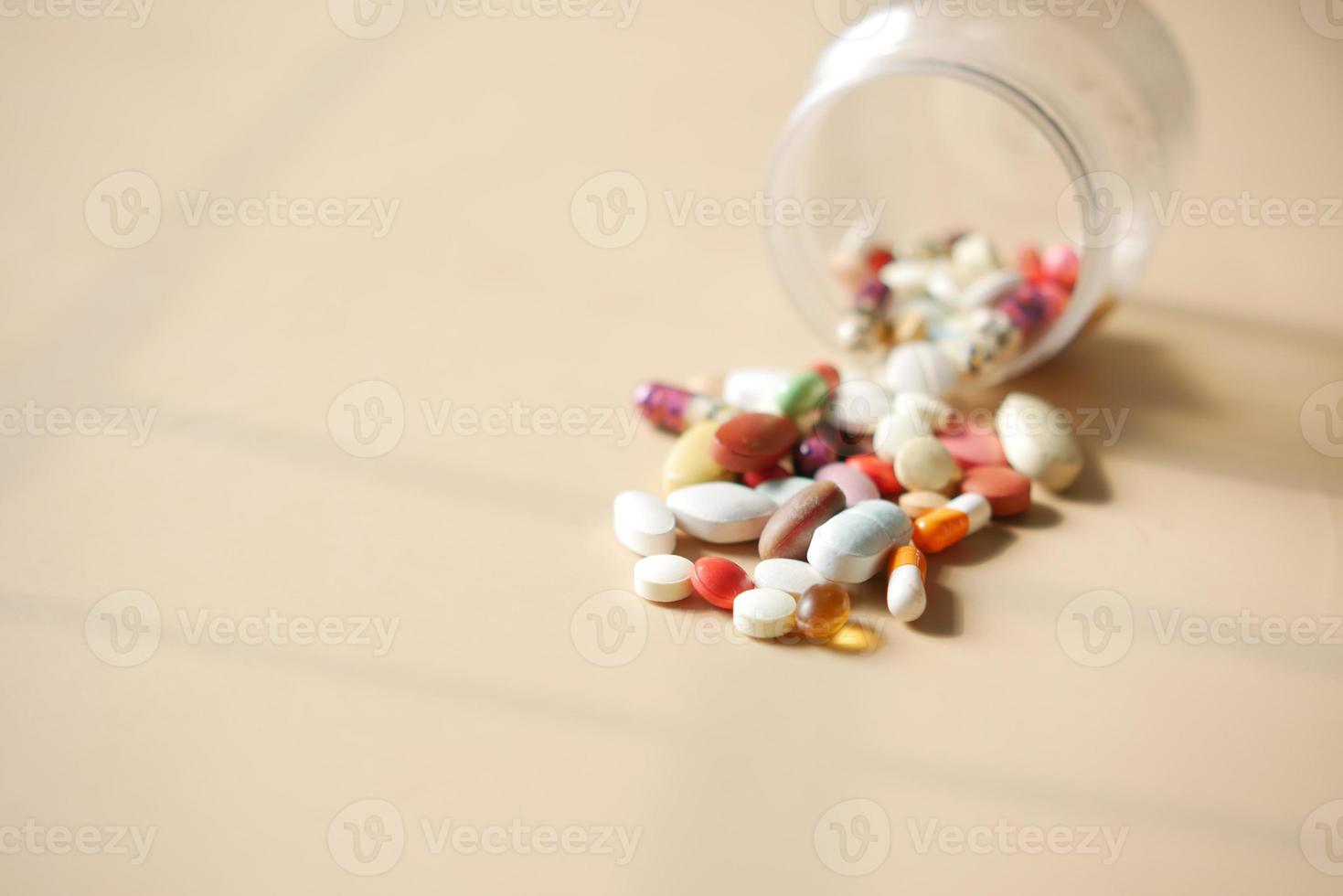 Close up di molte pillole e capsule colorate foto