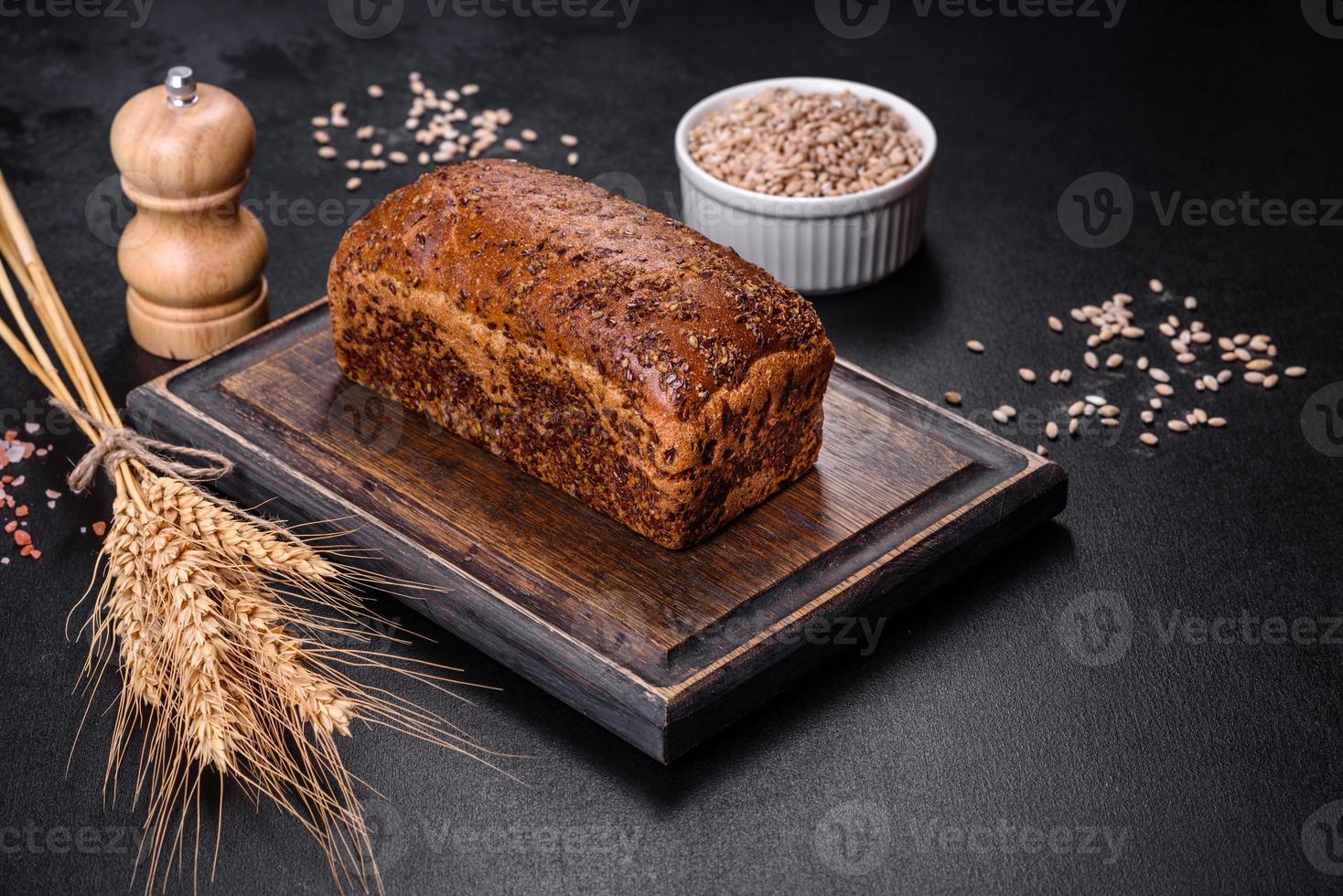 pane integrale appena sfornato con spighe e chicchi di grano foto