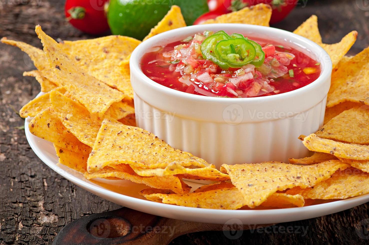 patatine nacho messicano e salsa tuffo in una ciotola su fondo di legno foto