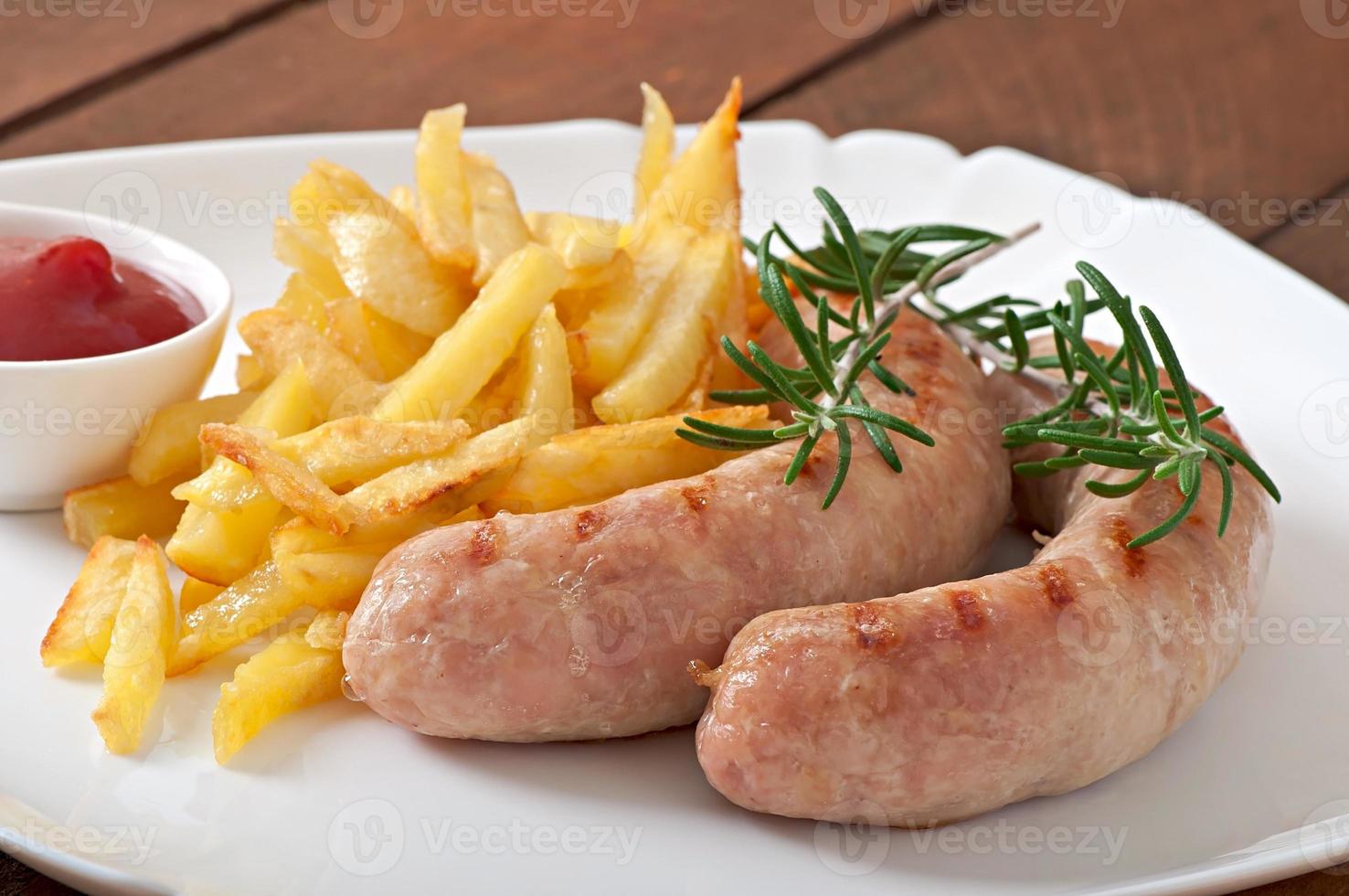 salsicce di pollo grigliate con contorno di patatine fritte foto