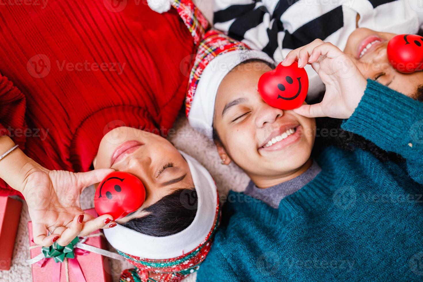 famiglia afroamericana in tema natalizio. felice famiglia afroamericana di quattro persone che si legano insieme sul pavimento. foto