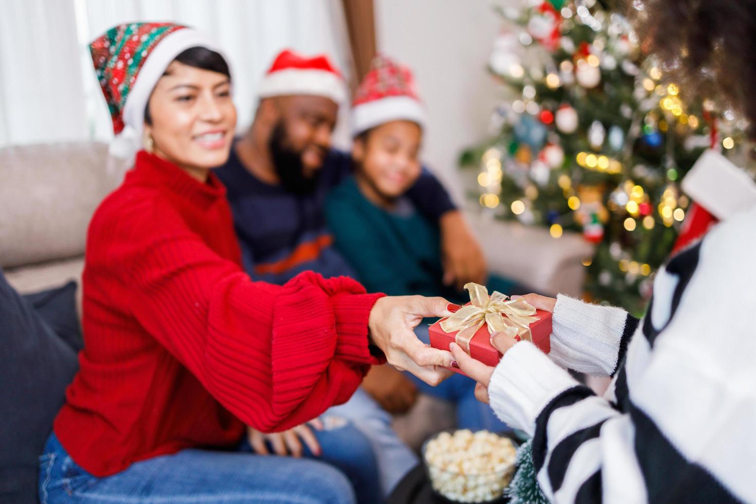 famiglia afroamericana sorpresa con un regalo il giorno di natale. buon Natale. foto