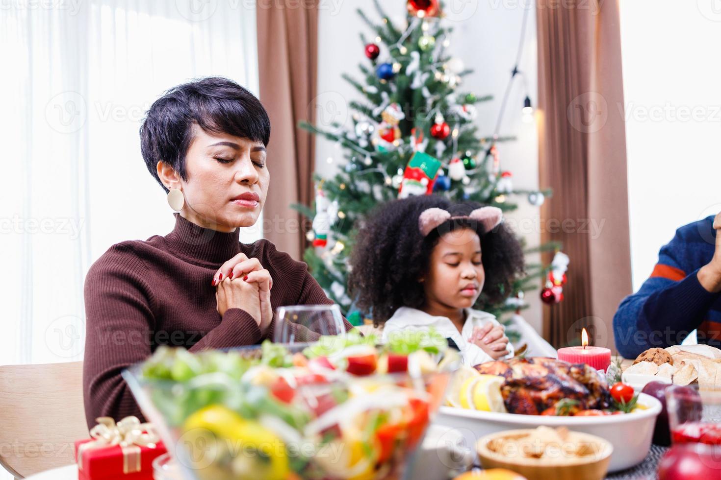 famiglie insieme per pregare prima dei pasti a casa. foto