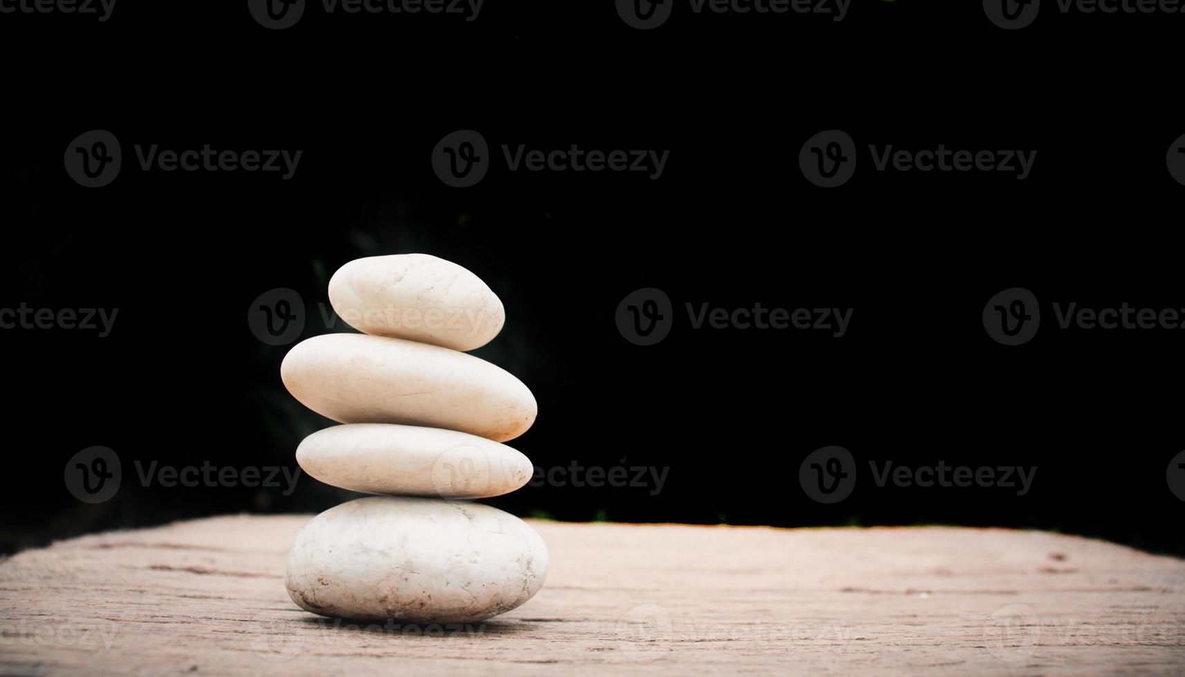 pietre zen su legno su sfondo nero. foto