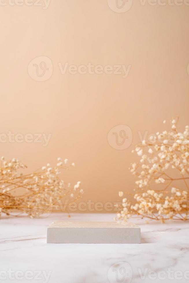 una scena minimalista di un podio con fiori di gipsofila su fondo beige chiaro foto