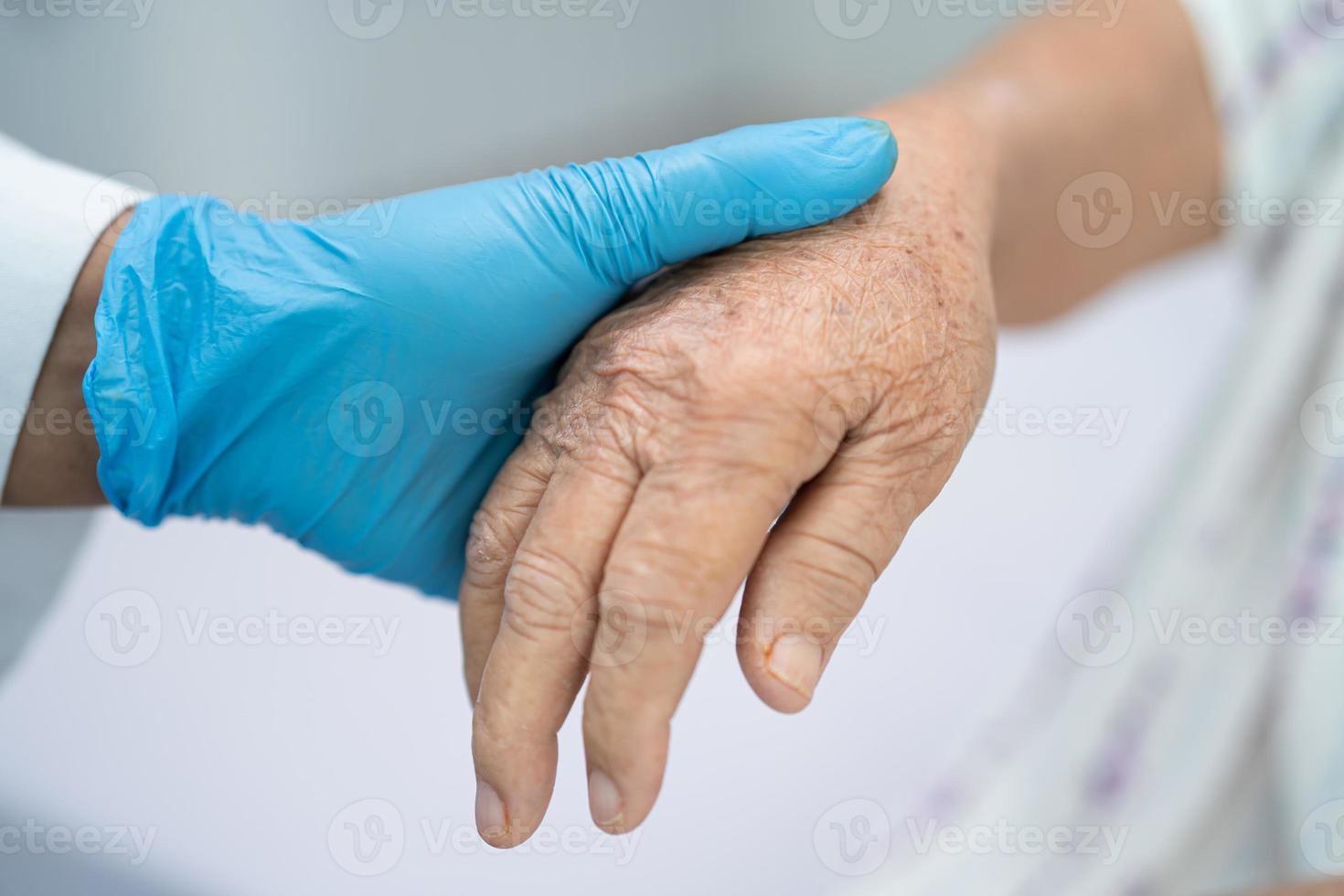 medico che tiene le mani toccanti asiatica anziana o anziana signora anziana paziente con amore, cura, aiuto, incoraggiamento ed empatia nel reparto ospedaliero di cura, concetto medico sano e forte foto