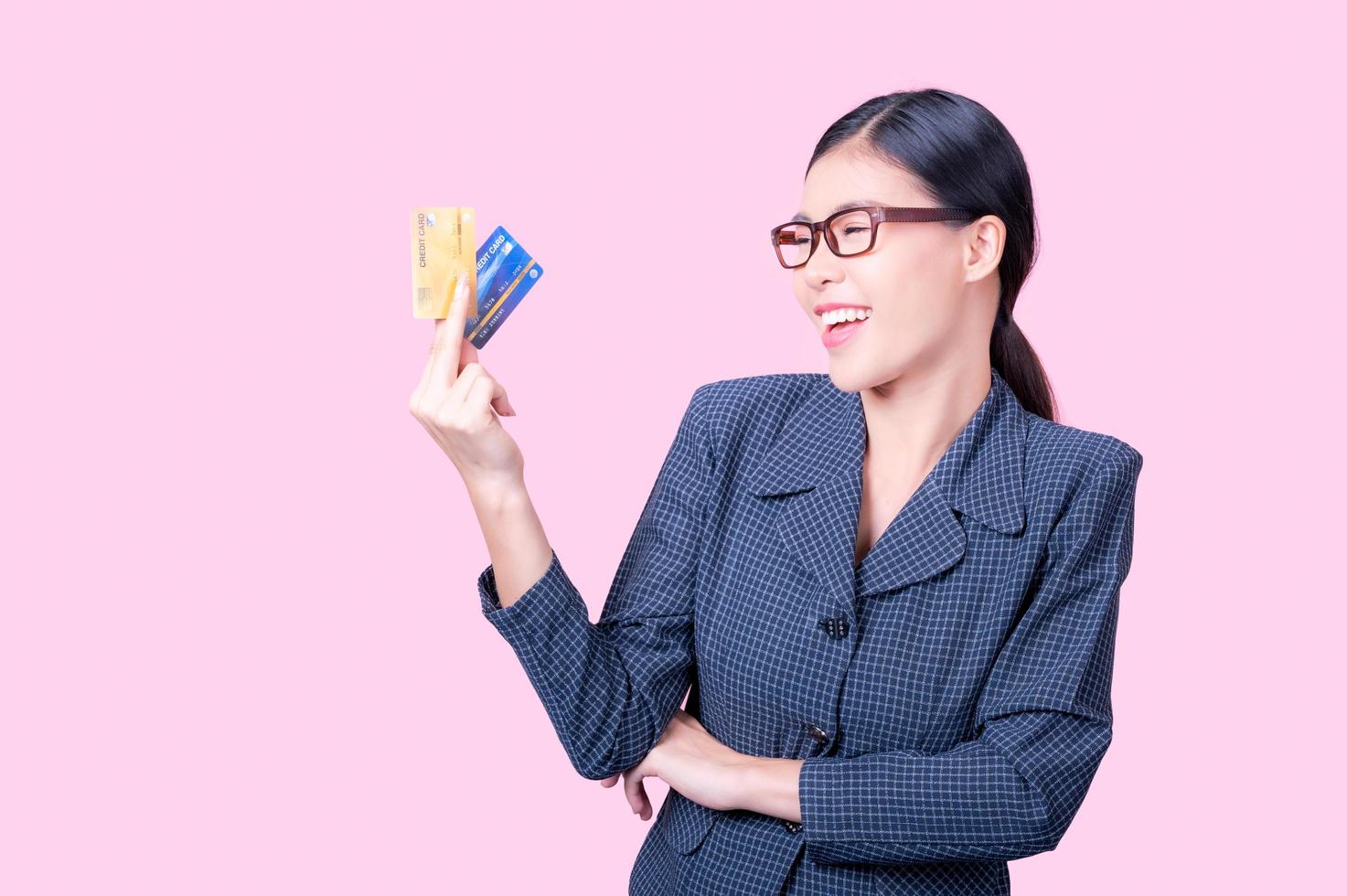 una bella donna asiatica è felice e pensa che spenderà con molte delle sue carte di credito foto