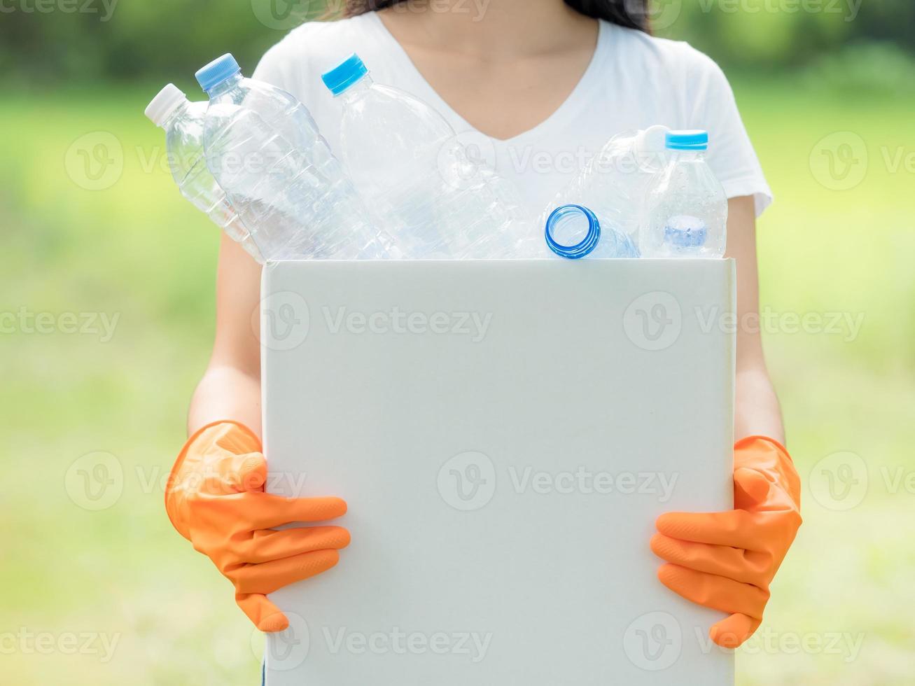donne volontarie raccolgono bottiglie d'acqua di plastica nell'area del parco foto