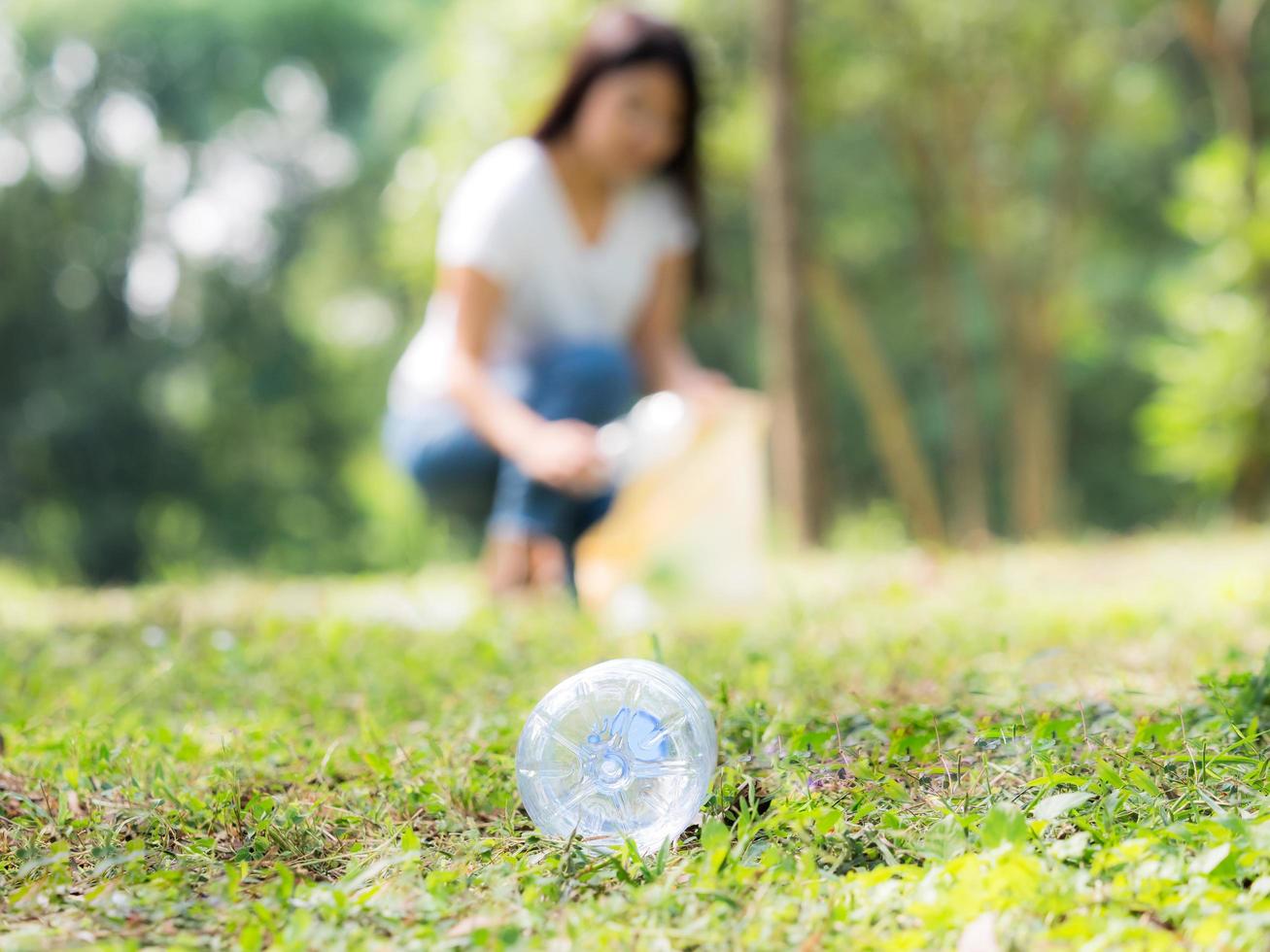 donne volontarie raccolgono bottiglie d'acqua di plastica nell'area del parco foto