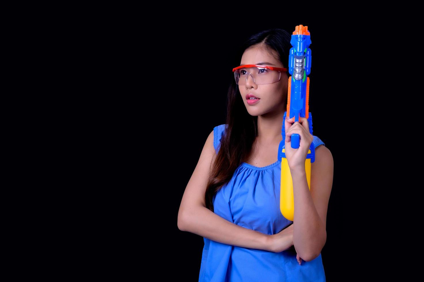 una bella donna asiatica mostra un gesto mentre tiene in mano una pistola ad acqua di plastica durante il festival di Songkran foto