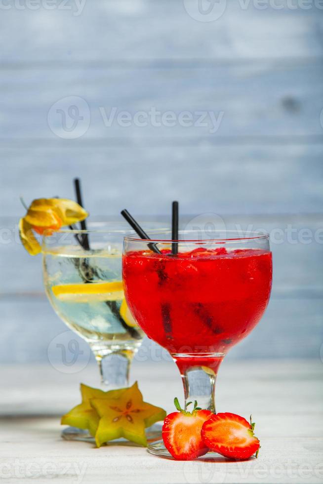 vari cocktail alcolici su sfondo bianco. cocktail colorati da vicino. bevanda cocktail succhi di frutta. bevande cocktail assortite. bicchieri di bevande alla frutta con cubetti di ghiaccio sul tavolo nella caffetteria foto