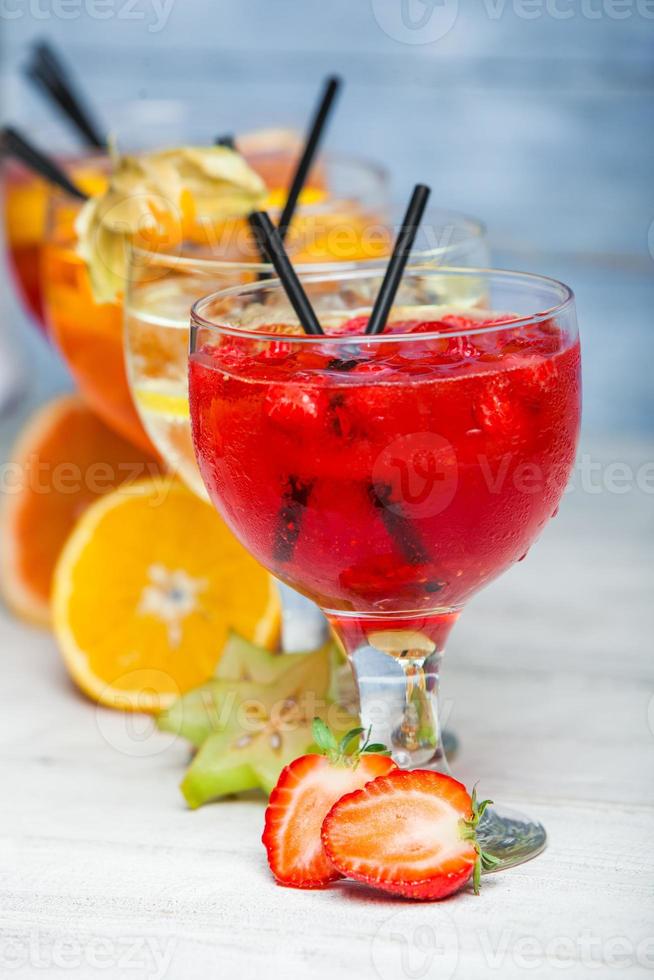 vari cocktail alcolici su sfondo bianco. cocktail colorati da vicino. bevanda cocktail succhi di frutta. bevande cocktail assortite. bicchieri di bevande alla frutta con cubetti di ghiaccio sul tavolo nella caffetteria foto