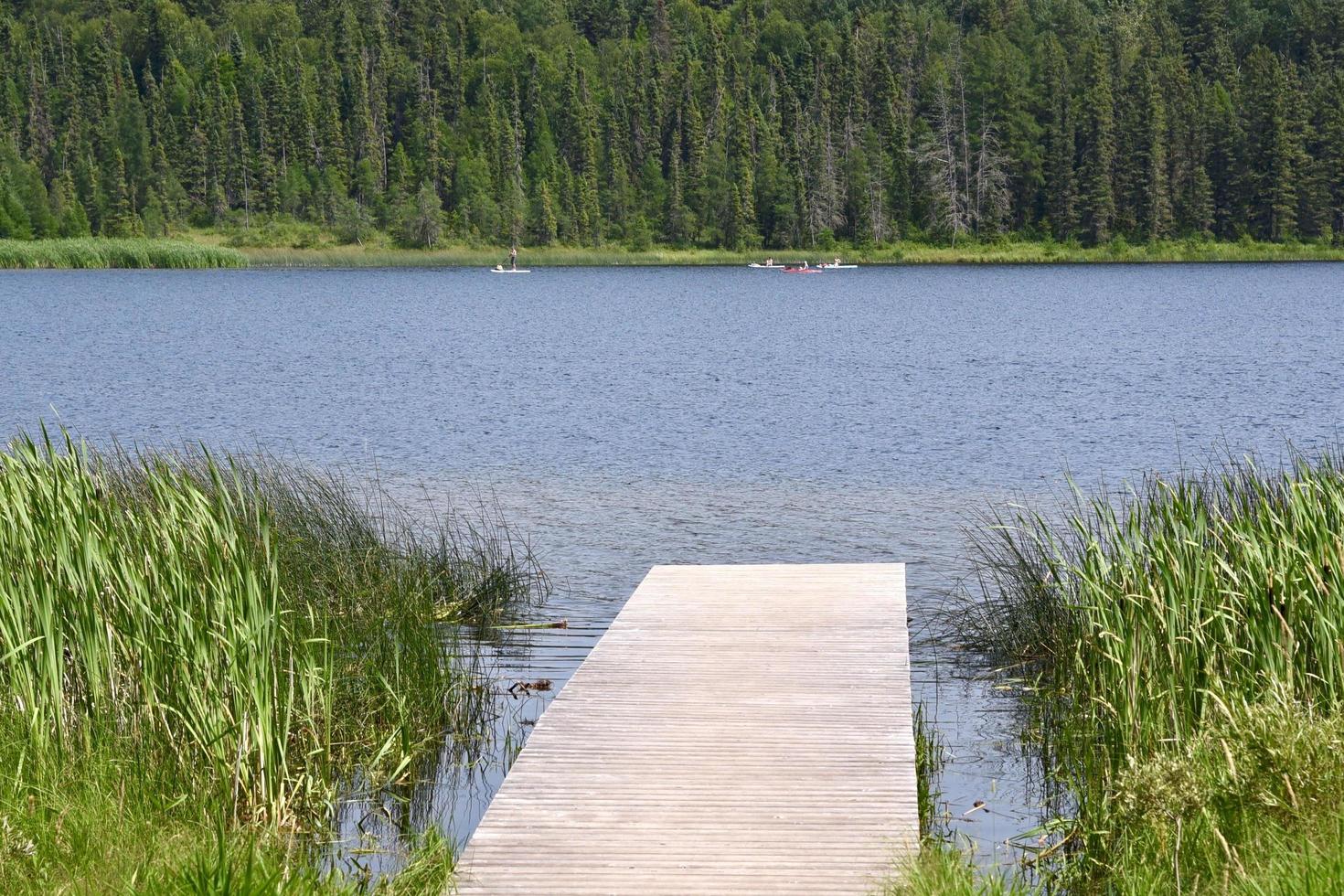 un molo di legno conduce in un lago calmo foto