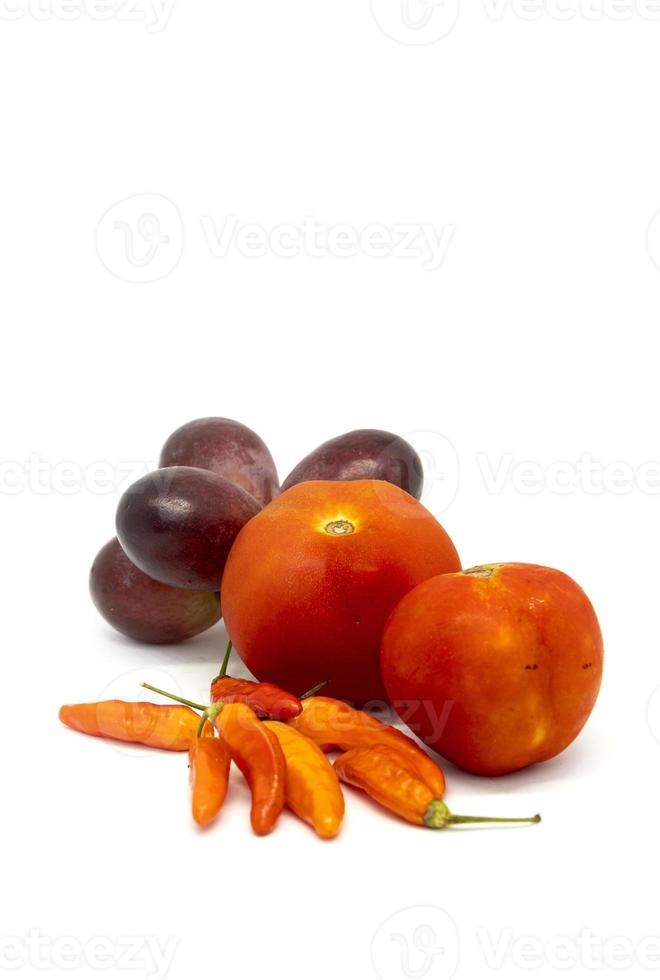peperoncini vegetali, pomodori e uva fresca su sfondo bianco foto
