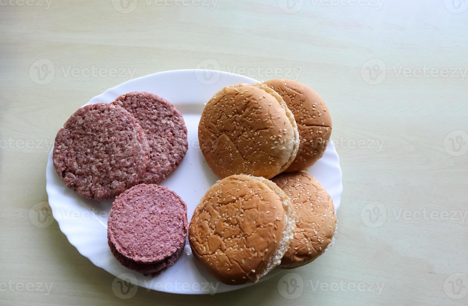 preparazione fatta in casa di un hamburger alla griglia con pomodori e insalata su un piatto foto