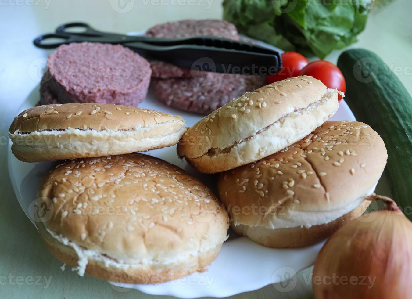 preparazione fatta in casa di un hamburger alla griglia con pomodori e insalata su un piatto foto