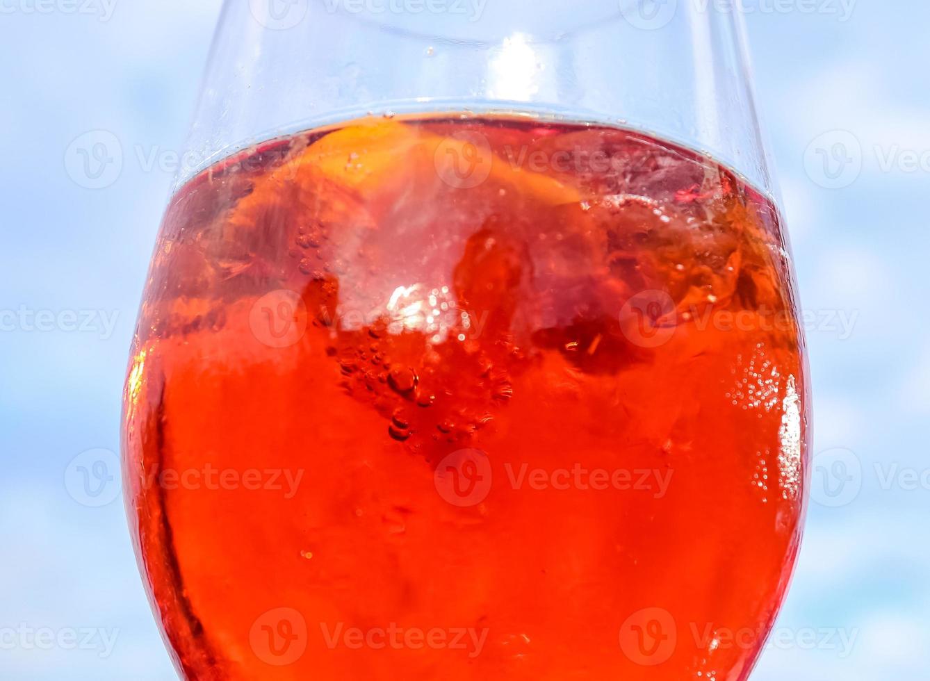 rinfrescanti cocktail estivi arancioni con cola e ghiaccio su uno sfondo di cielo blu. vista ravvicinata. foto