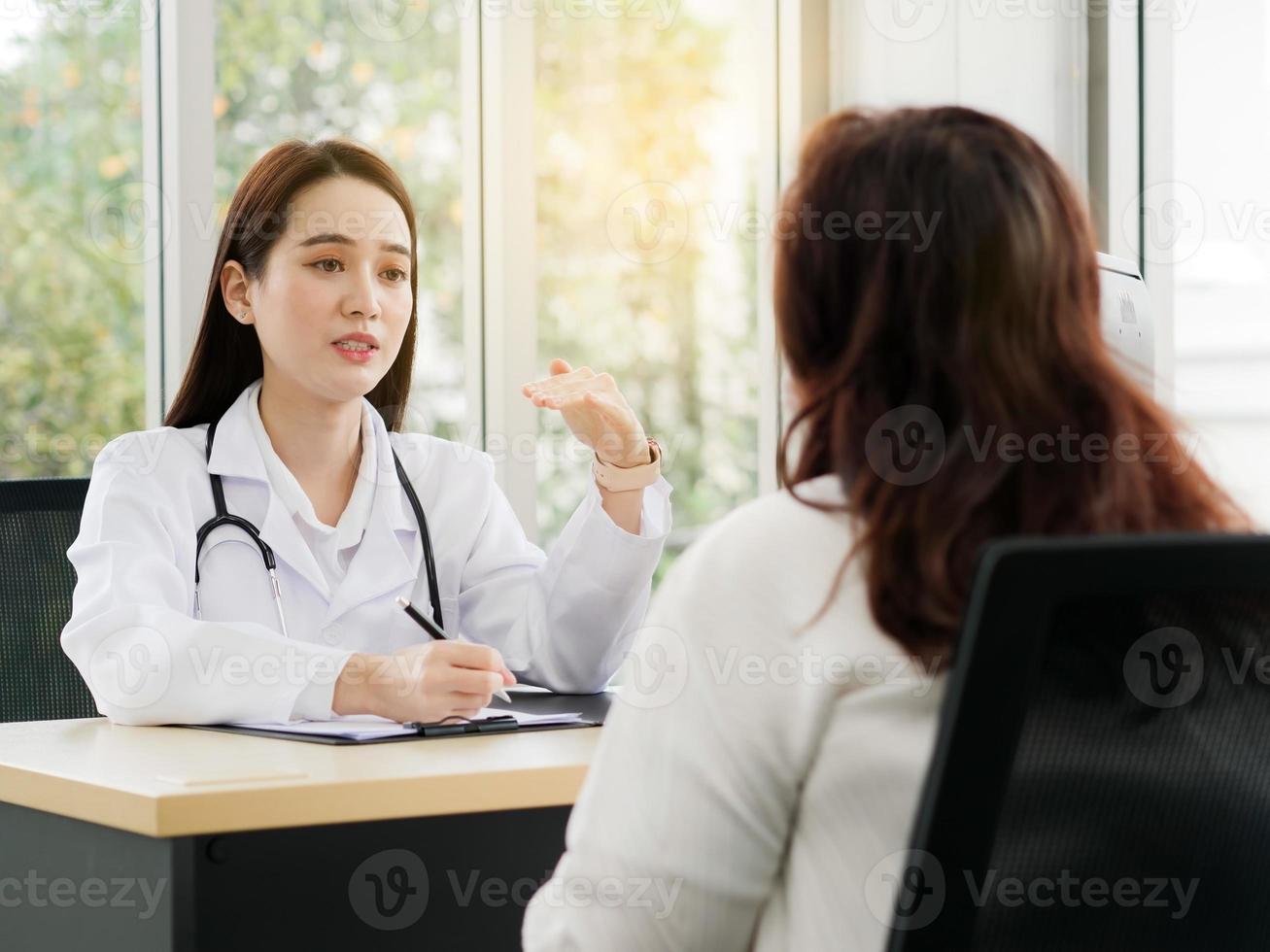 una dottoressa o un'infermiera sta parlando o intervistando una paziente di mezza età, idee per concetti sanitari. foto