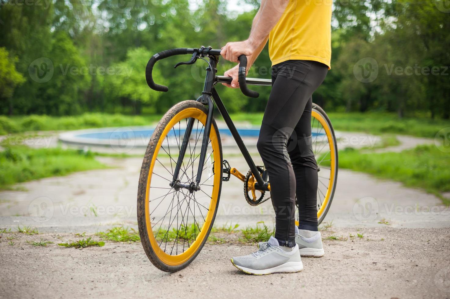 un giovane si è fermato a riposare con la sua bicicletta in un parco pubblico. foto