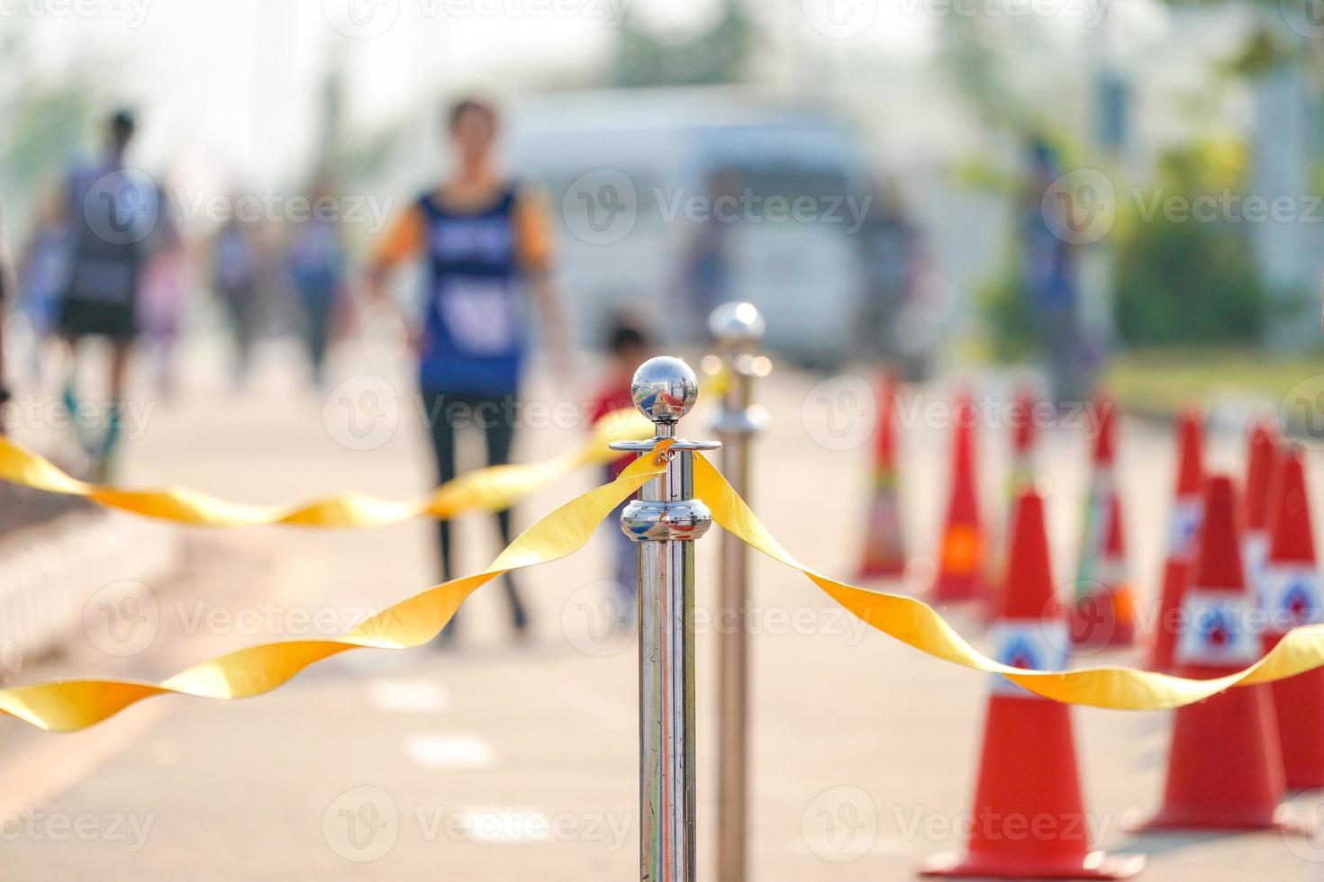 barricata inossidabile di lusso con nastro di corda gialla sulla strada nell'evento maratona al punto di arrivo. foto