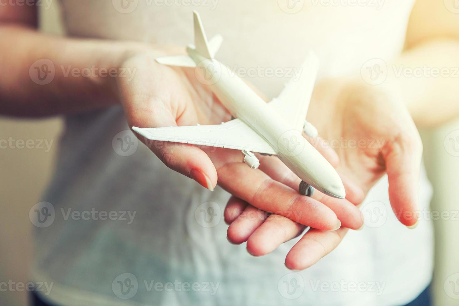 mani di donna femminile che tengono piccolo aereo modello giocattolo foto