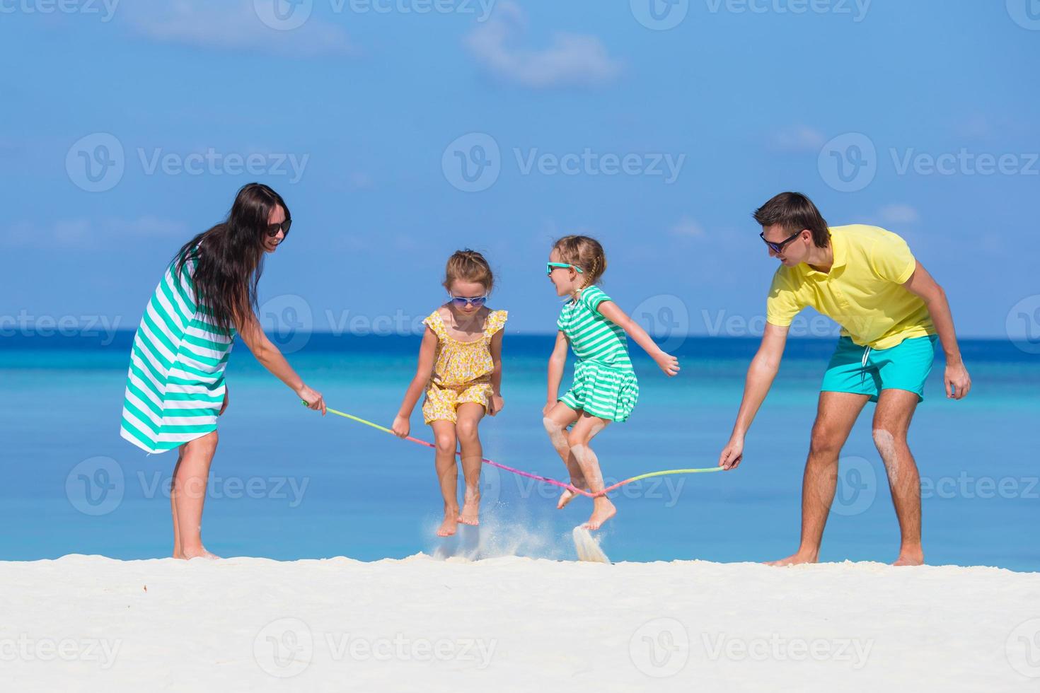 famiglia felice che gioca insieme sulla spiaggia bianca foto