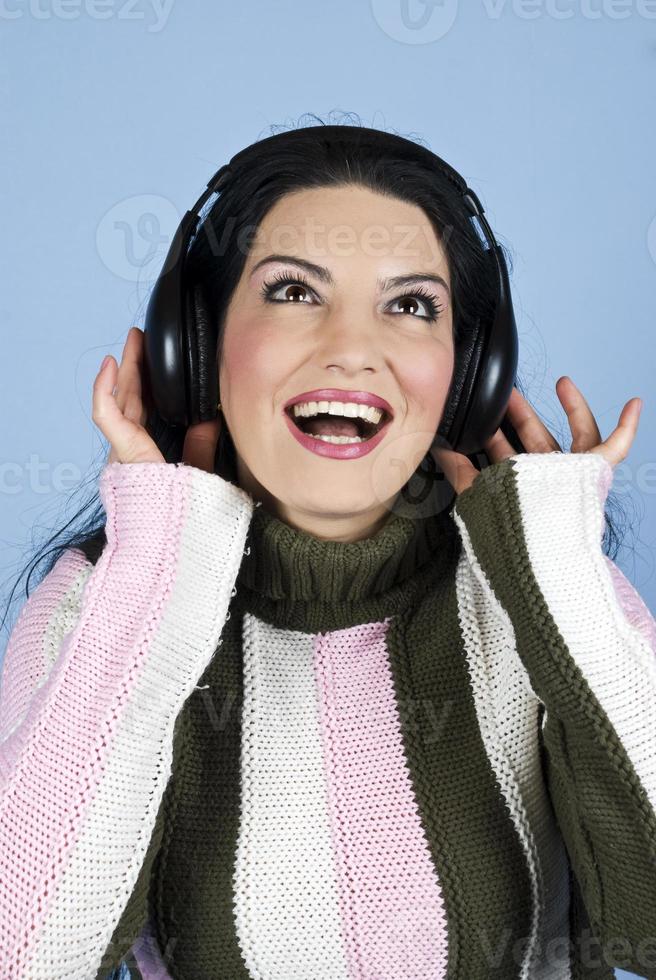 donna felice che gode della musica nelle cuffie foto