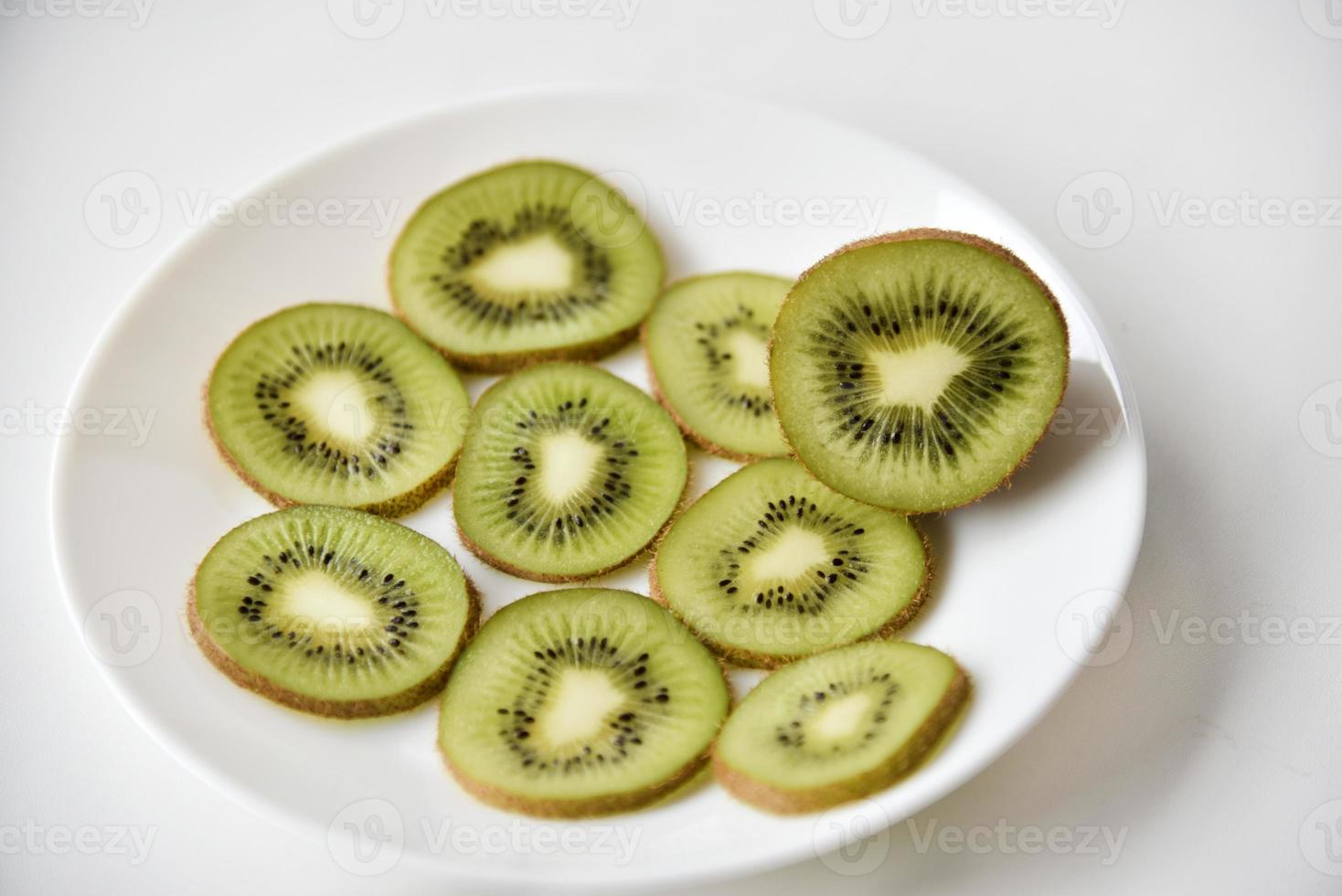 kiwi affettato su un piatto bianco foto