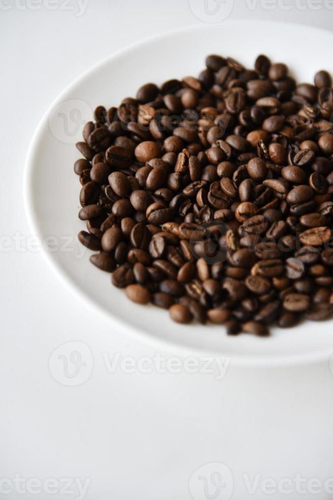chicchi di caffè tostati su un piatto bianco foto