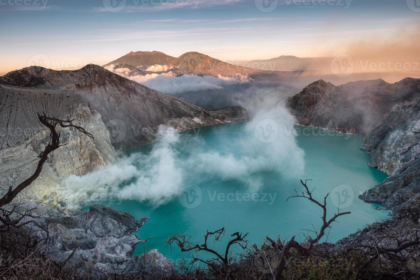 cratere del vulcano attivo con lago turchese e fumo di zolfo al mattino foto