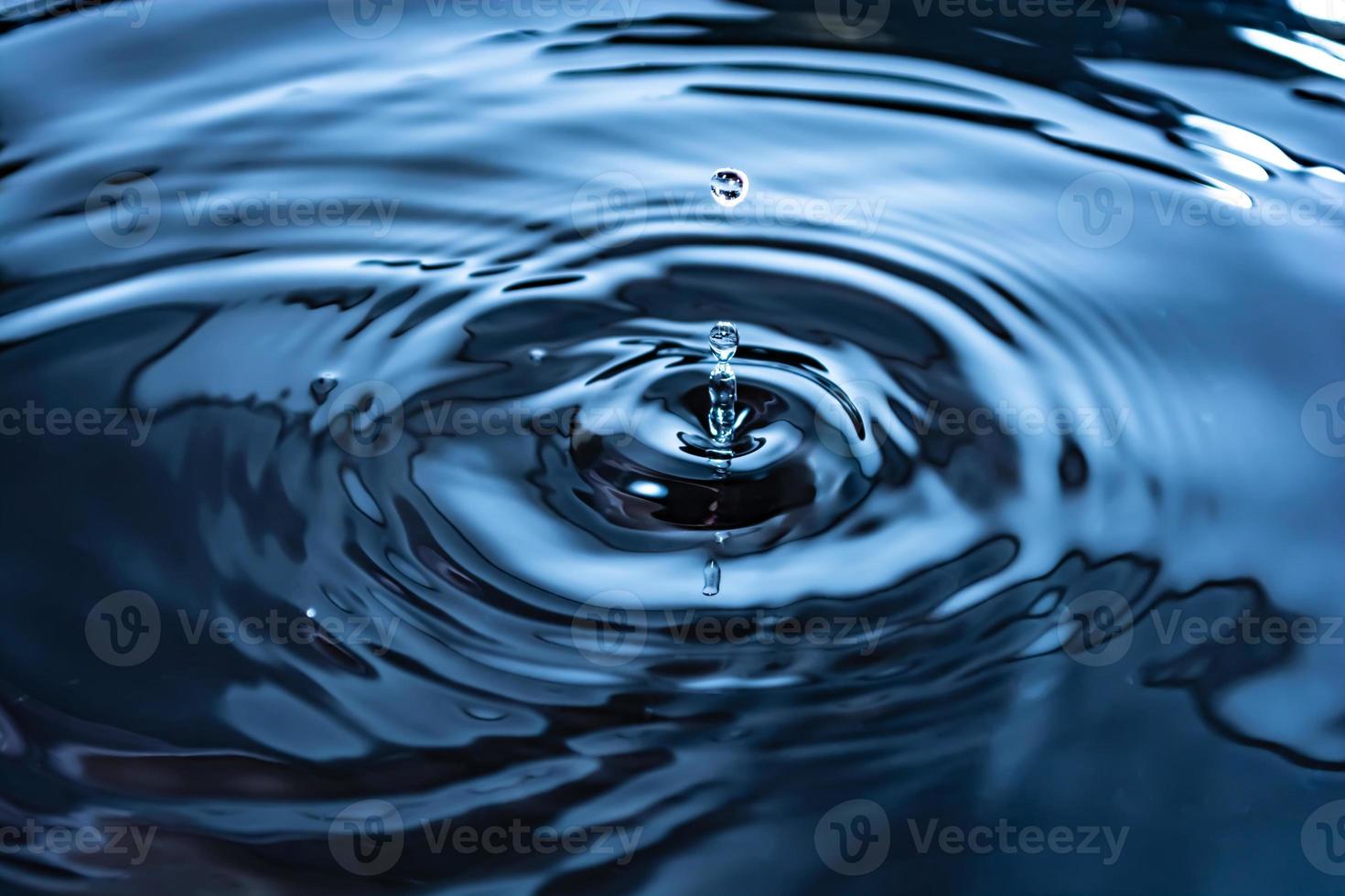 gocce e increspature. primo piano di anelli d'acqua blu, riflessi circolari, onde sulla superficie del liquido. foto