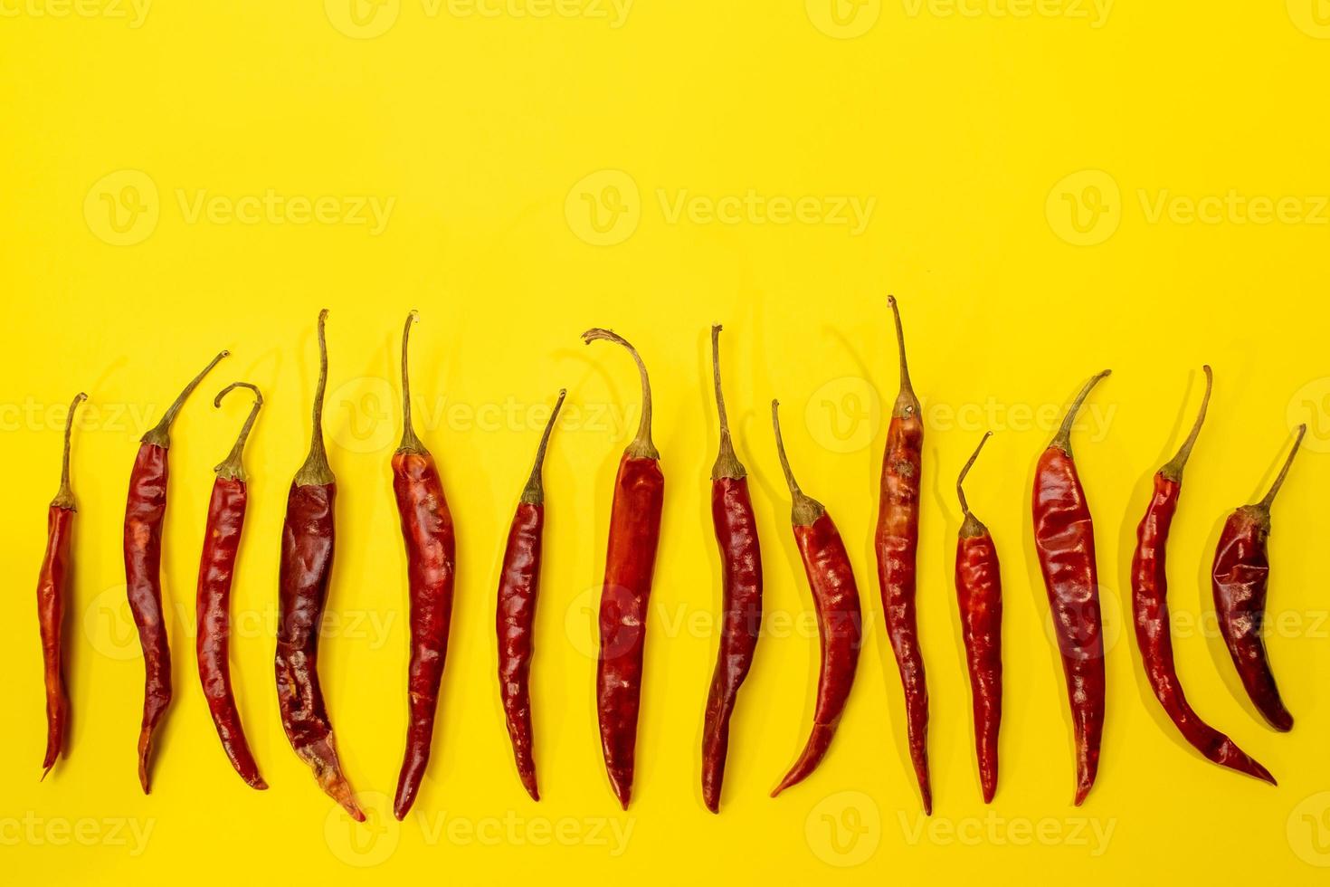 chilis rosso chile de arbol disposto come modello su sfondo giallo vivace divertente foto
