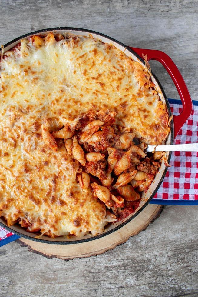 Gusci di pasta al pomodoro al formaggio in piatto di ghisa piatto foto