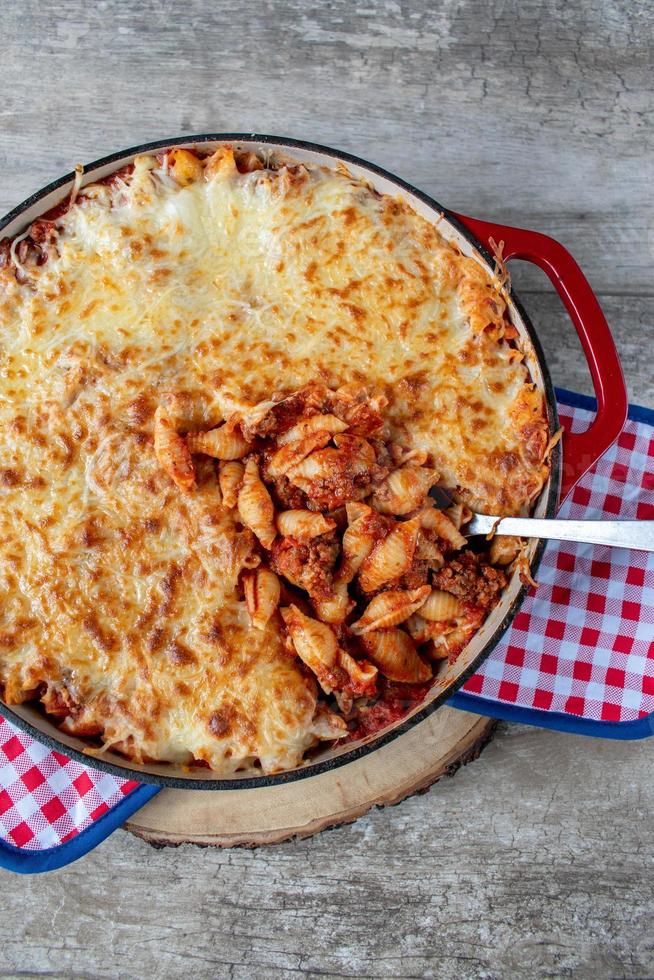 Gusci di pasta al pomodoro al formaggio in piatto di ghisa piatto foto