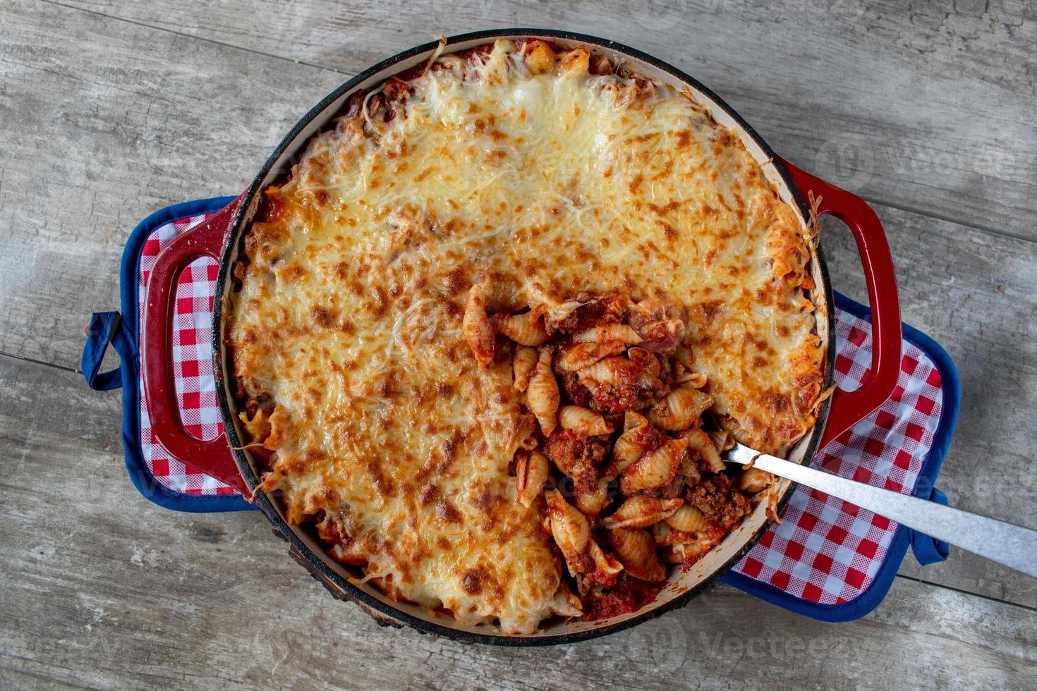 Gusci di pasta al pomodoro al formaggio in piatto di ghisa piatto foto