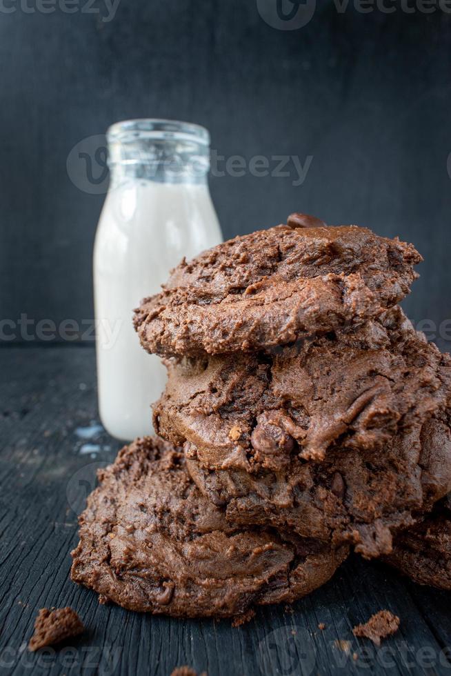 pila di biscotti al cioccolato con latte su tavola di legno rustico foto