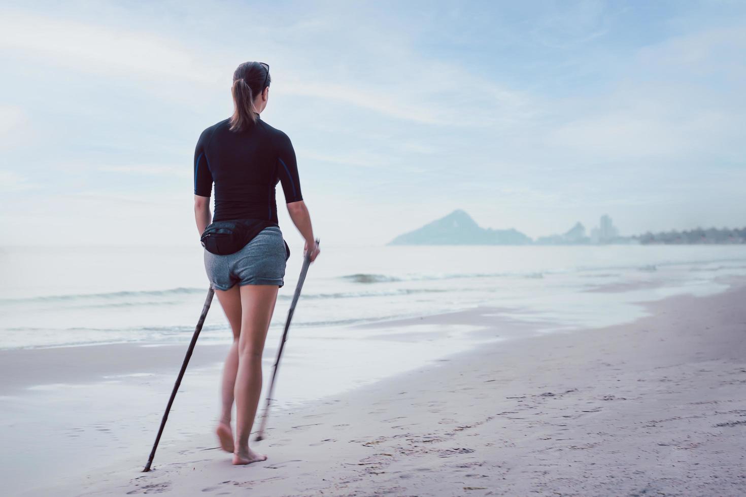 donna che fa un'escursione sulla sfocatura movimento spiaggia. stile di vita attivo e sano. foto