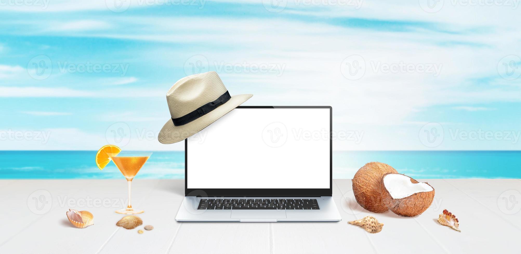 mockup di laptop con cappello bianco in mostra su superficie bianca con noci di cocco, conchiglie e cocktail d'arancia foto