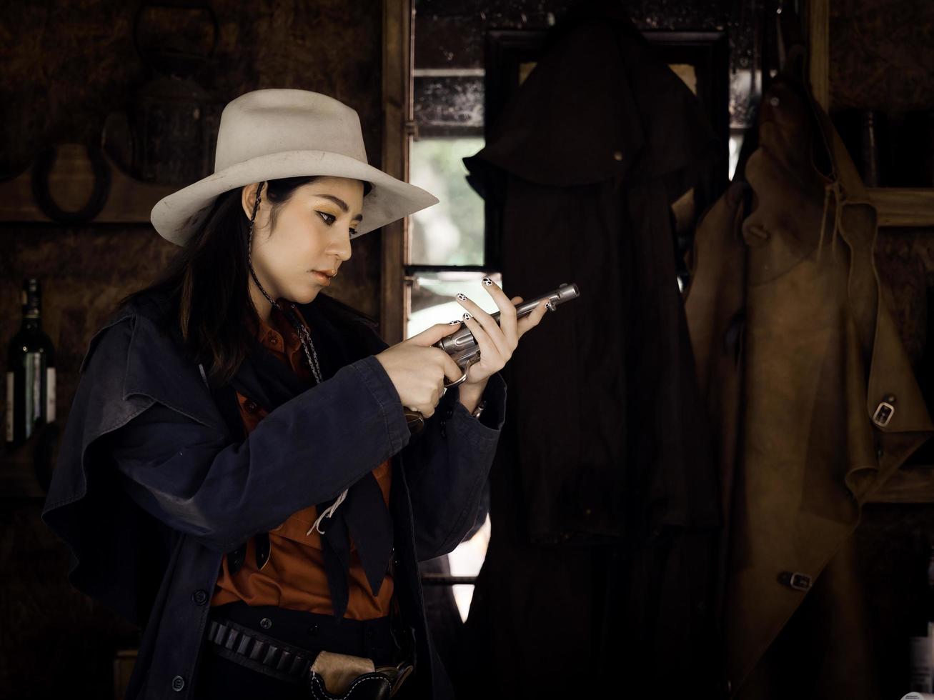 cowgirl western si prepara per le munizioni da difendere a colpi di arma da fuoco in una terra in cui le persone devono proteggersi foto