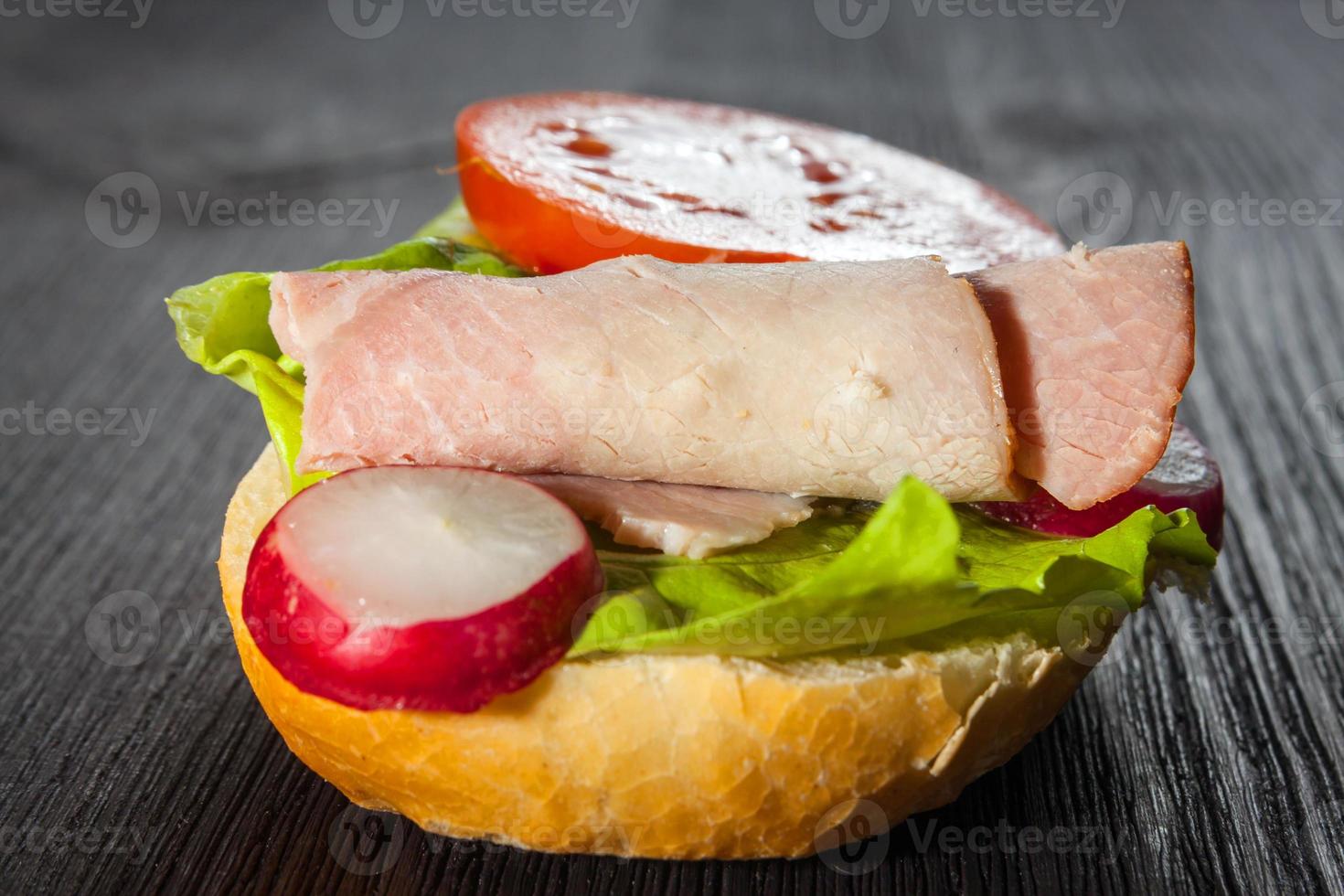 prosciutto, insalata panino sottomarino da baguette appena tagliata foto