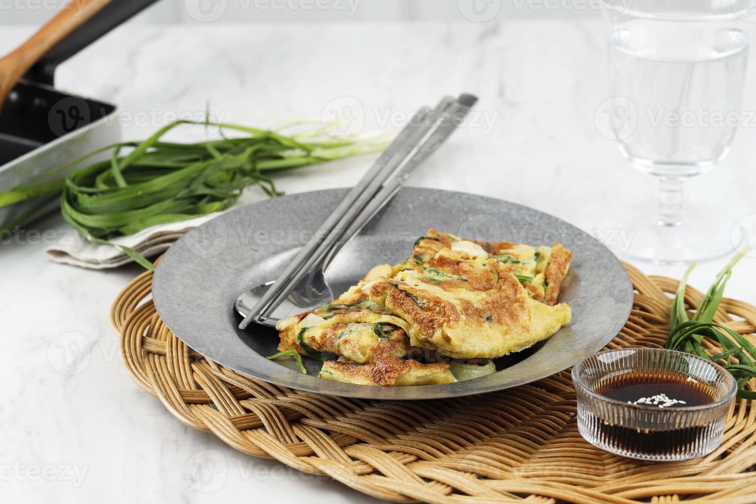 frittella di erba cipollina, popolare come frittella di pajeon in Corea. a base di uova, farina, cipolla ed erba cipollina o scalogno di cipolla verde. servito con salsa di soia e spolverata di semi di sesamo foto