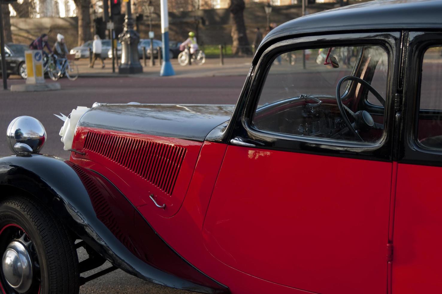 bella auto d'epoca rossa e nera parcheggiata in una strada londinese. foto